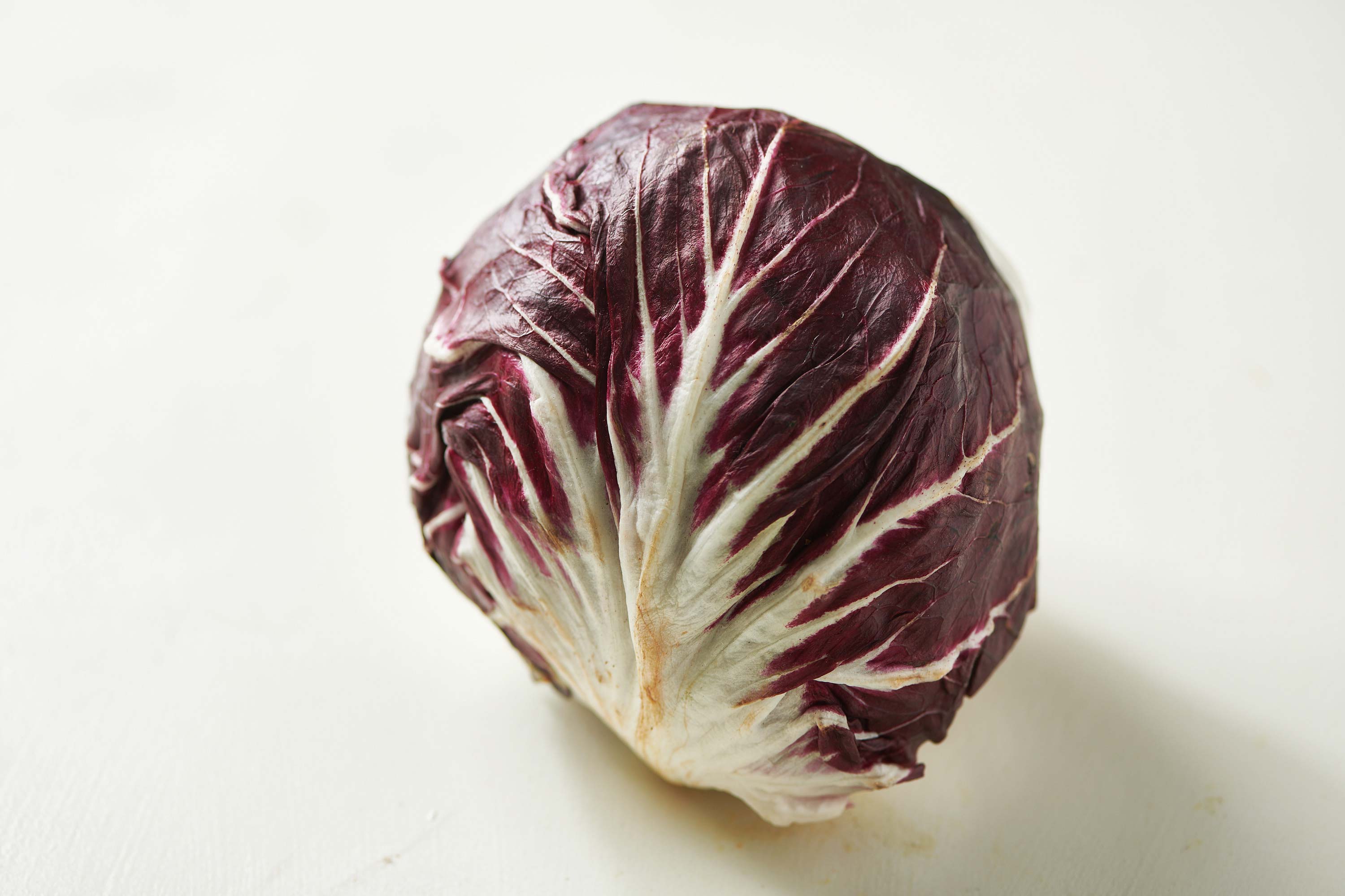 Italian radicchio head on white table.