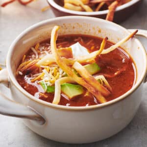 Mexican Tortilla Chicken Soup in white bowl on table.