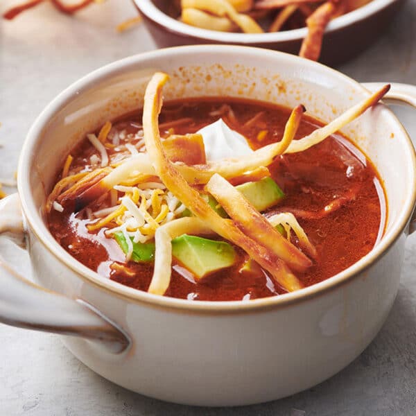 Mexican Tortilla Chicken Soup in white bowl on table.