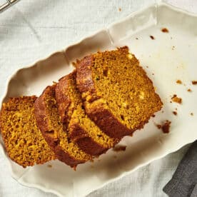 Sliced pumpkin bread on white plate.