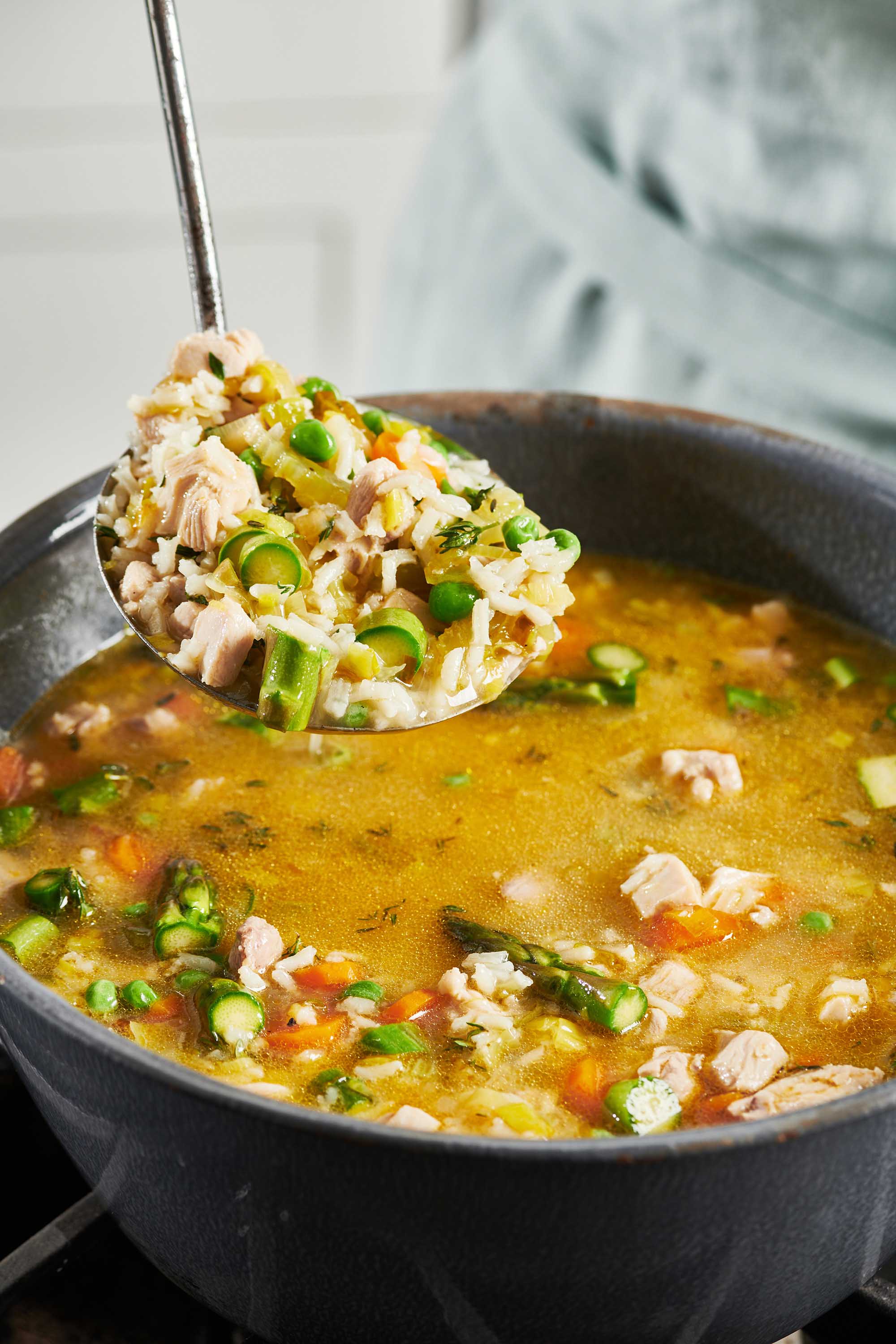 Ladle scooping Chicken and Rice Soup.