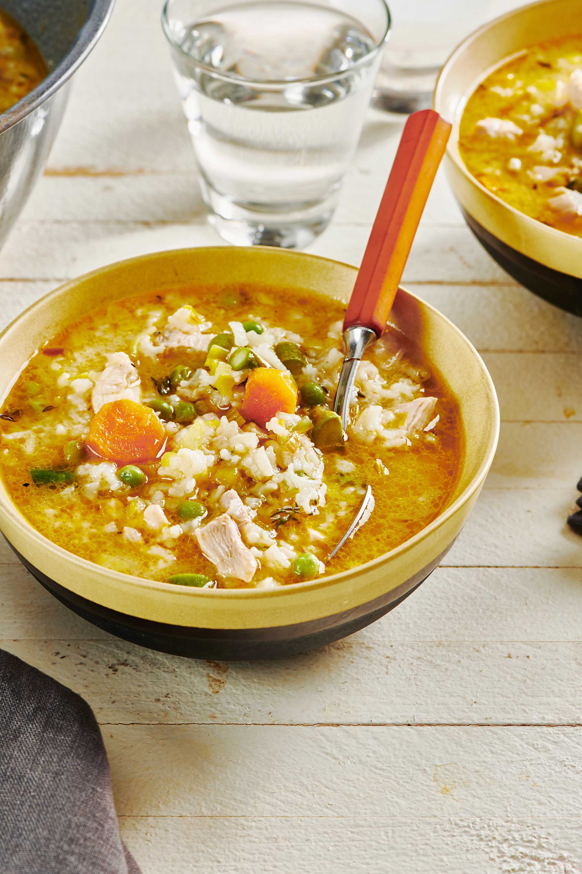 Bowl of Chicken and Rice Soup with a spoon.