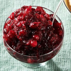 Spoon in a glass bowl of Cranberry Sauce.