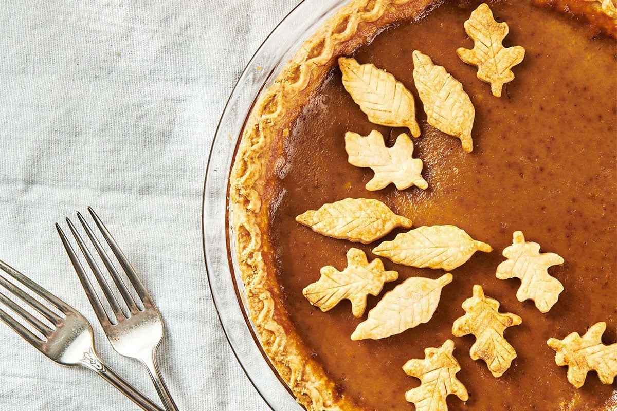 Pumpkin pie in pie dish with pastry leaves on top.