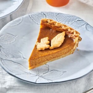 Slice of Pumpkin Pie with two pie crust leaves.