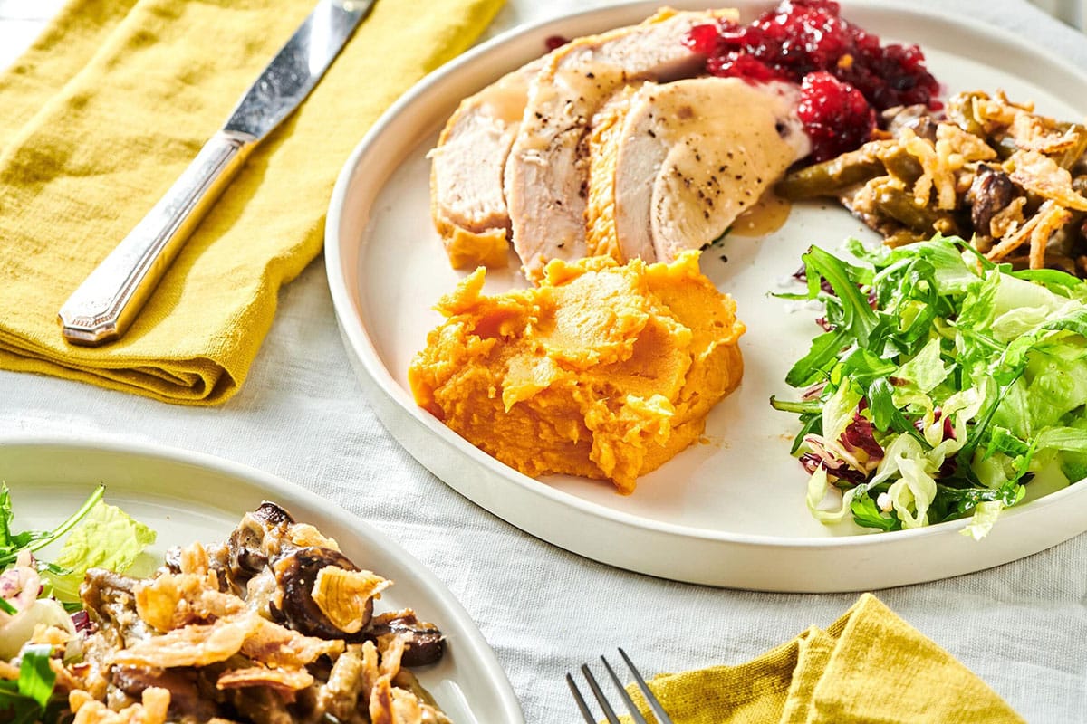 Plate of turkey, cranberry sauce, salad, and Garlic Mashed Sweet Potatoes.