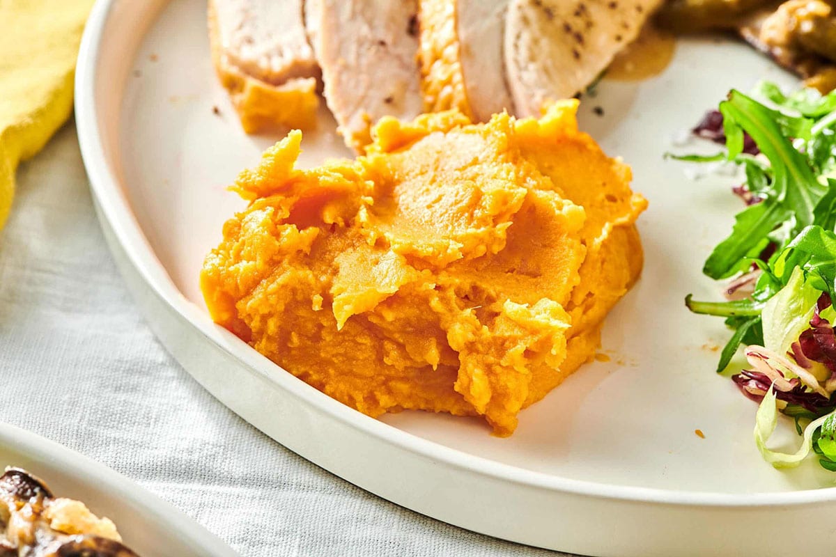 Garlic Mashed Sweet Potatoes on plate with turkey and salad.