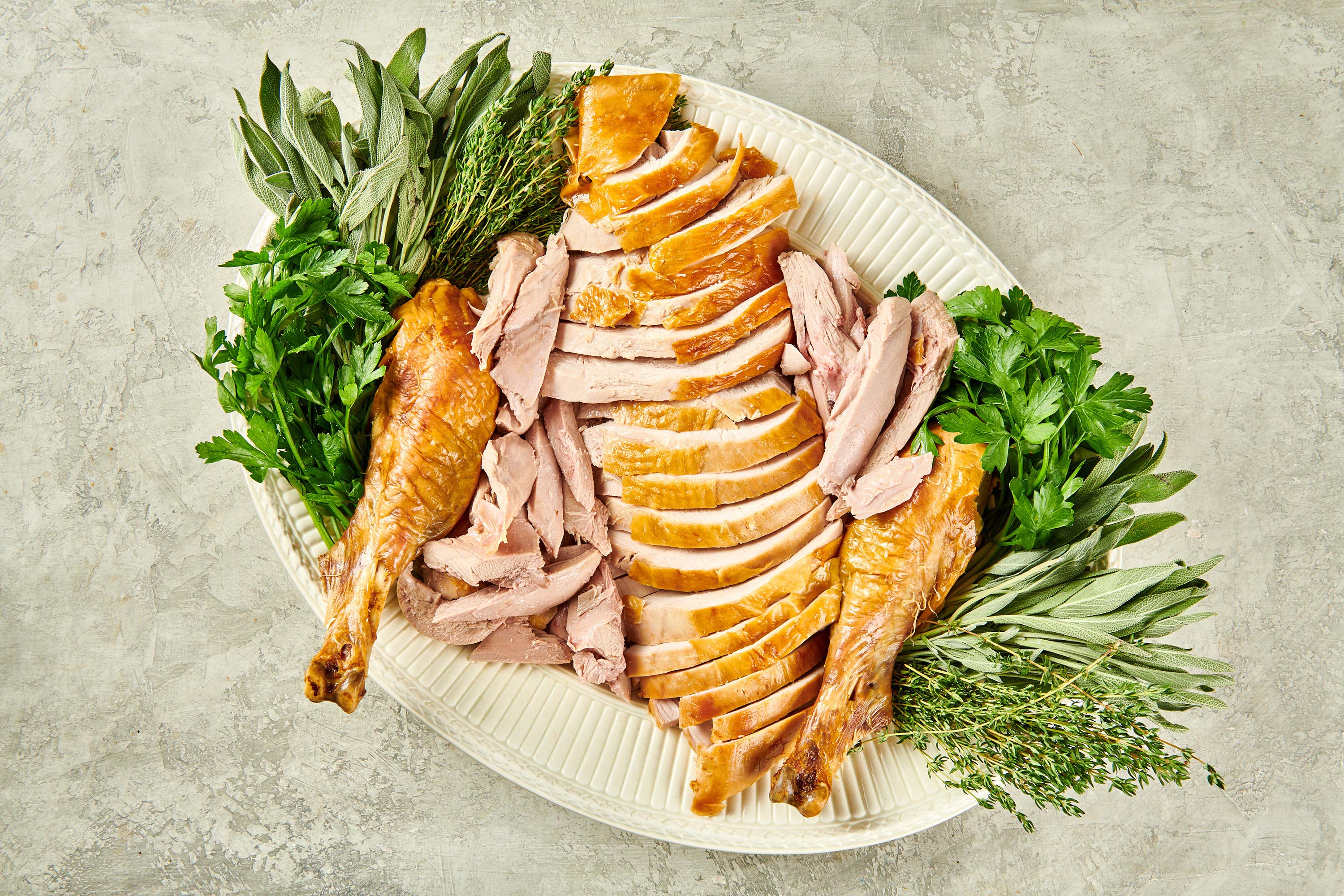 Platter of herbs and carved turkey.