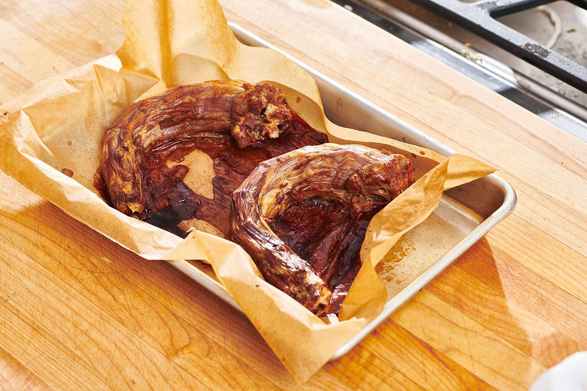 Turkey necks on a lined baking sheet.