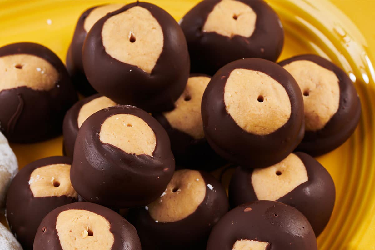 Chocolate covered buckeye balls on yellow plate