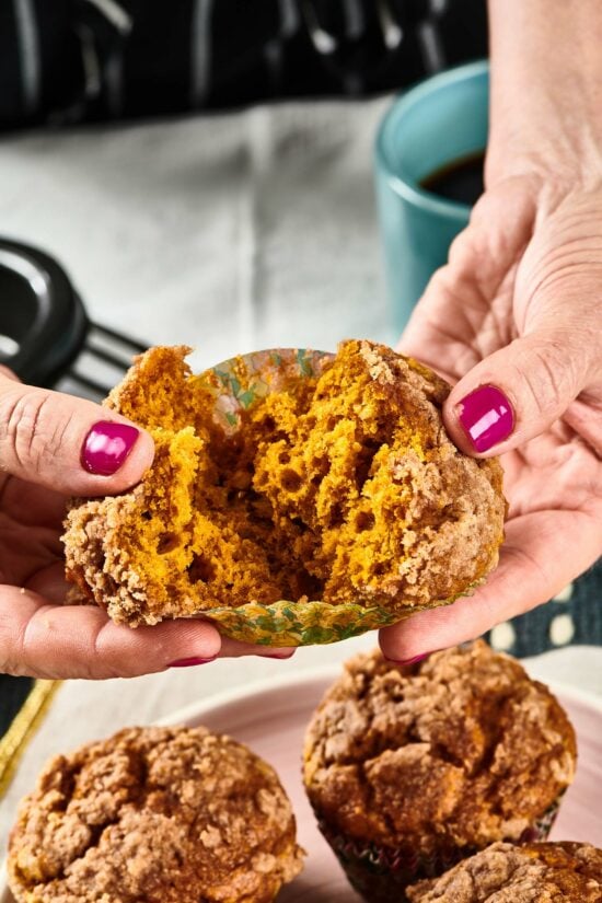 Woman pulling apart a Pumpkin Streusel Muffin.