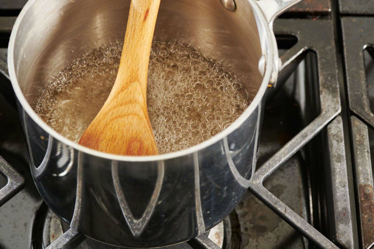 Wooden spoon in a bubbling pan of water and syrup.