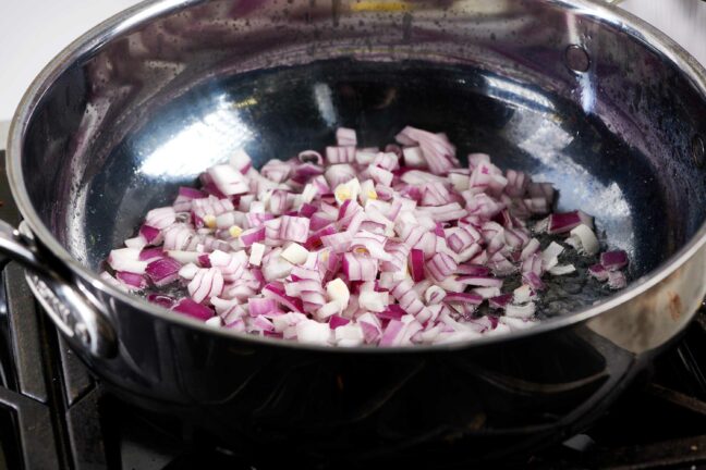 Diced red onions in a skillet.