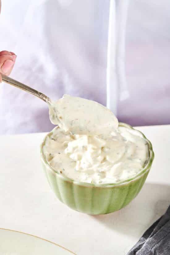 Spoon scooping Tartar Sauce from a bowl.