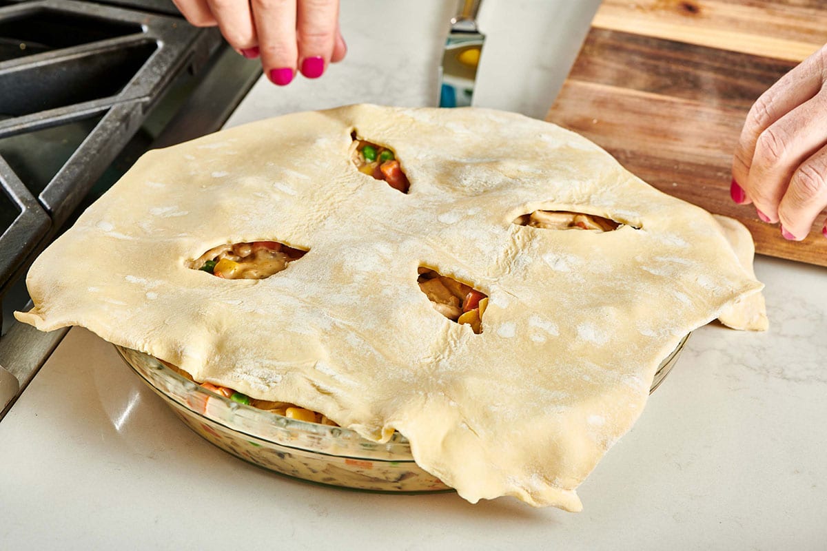 Sheet of dough with leaf cut-outs on top of a pan.