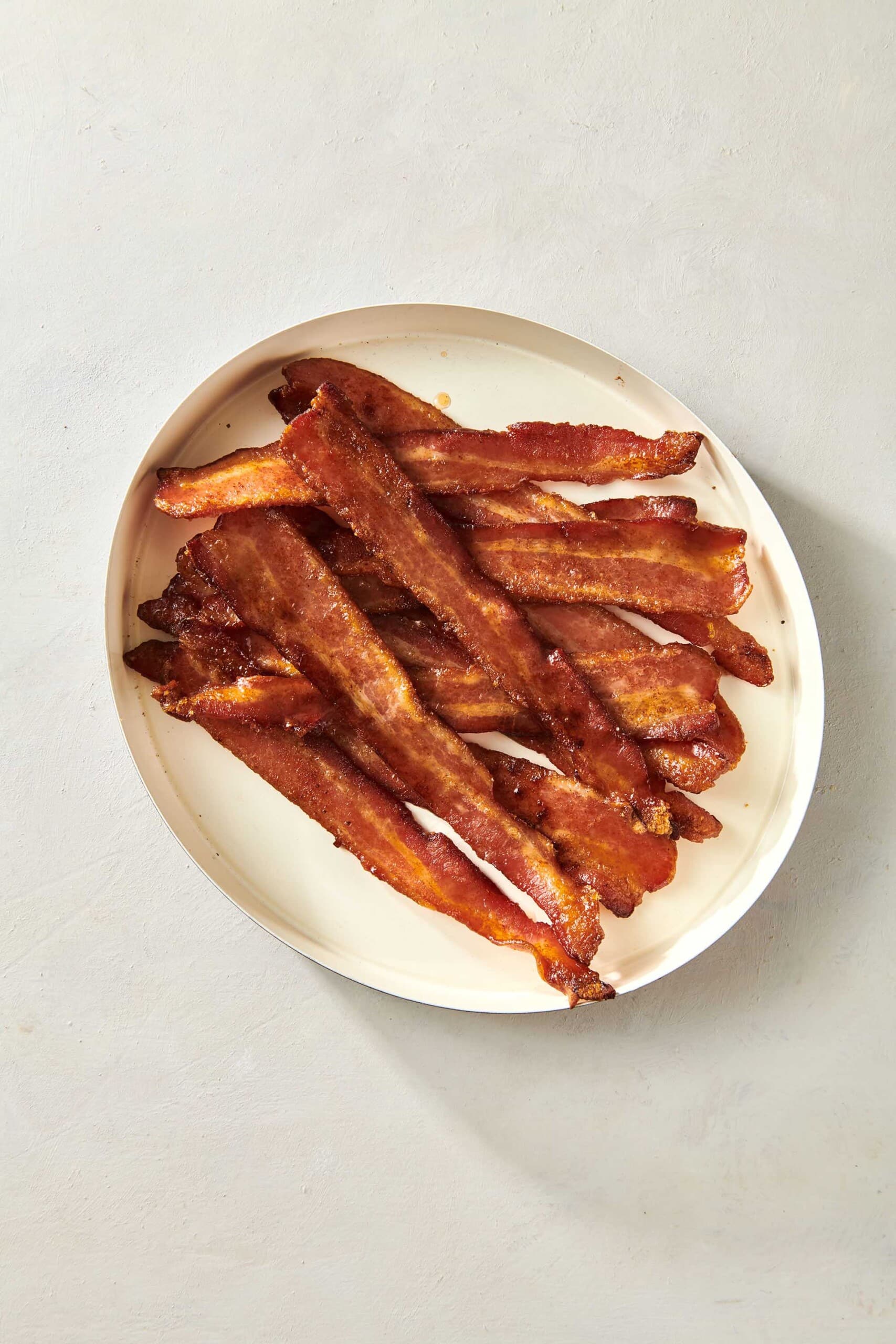 Candied Bacon piled on white plate.
