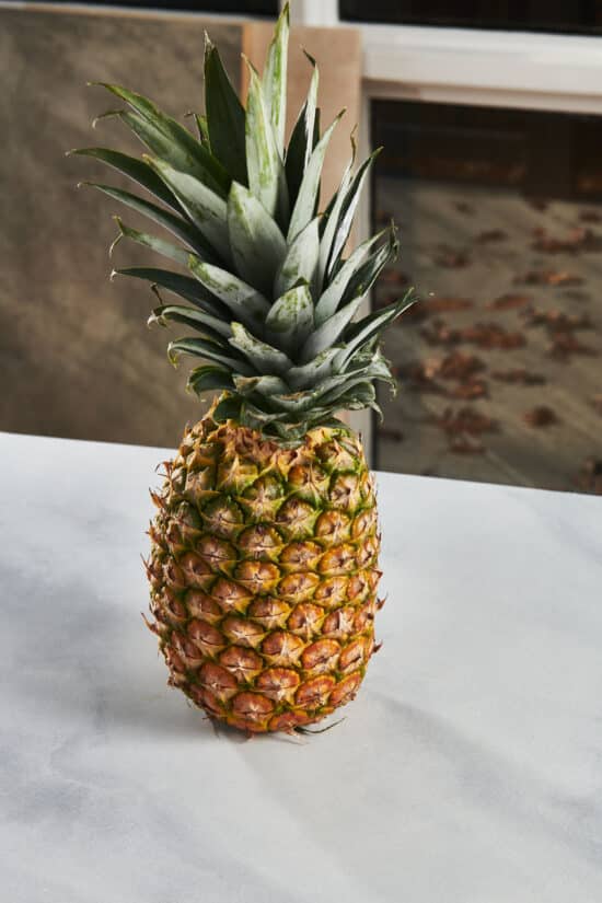 Whole pineapple on a marble counter.