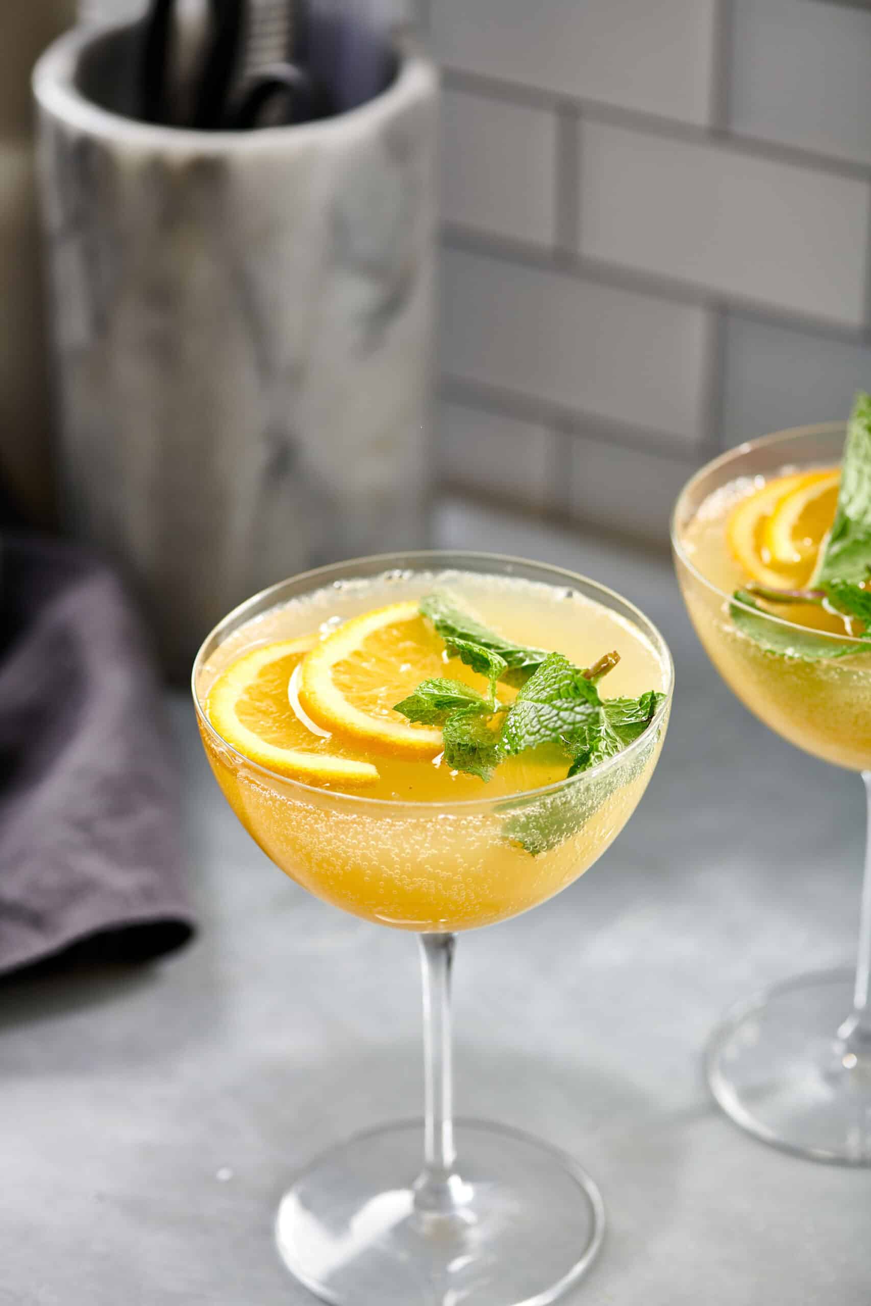 Orange champagne mules in long-stemmed glasses.