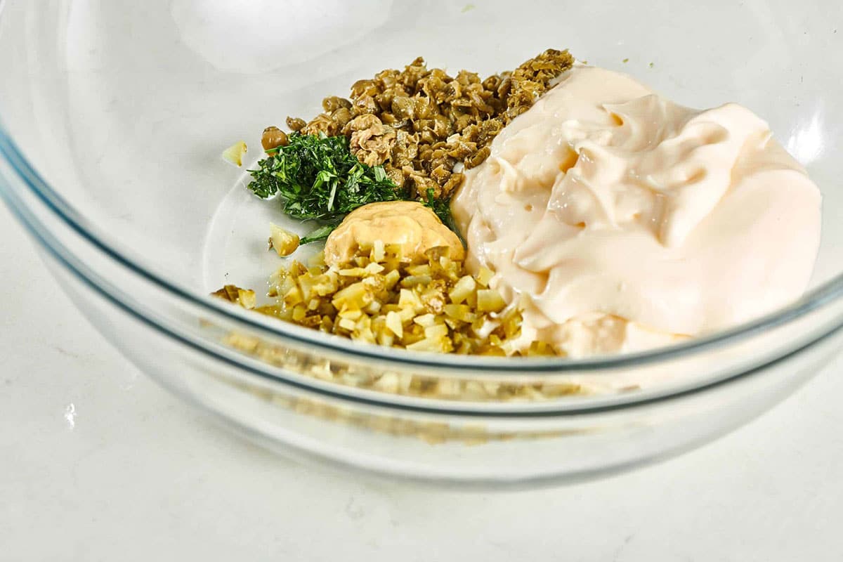 Glass bowl of unmixed Tartar Sauce ingredients.