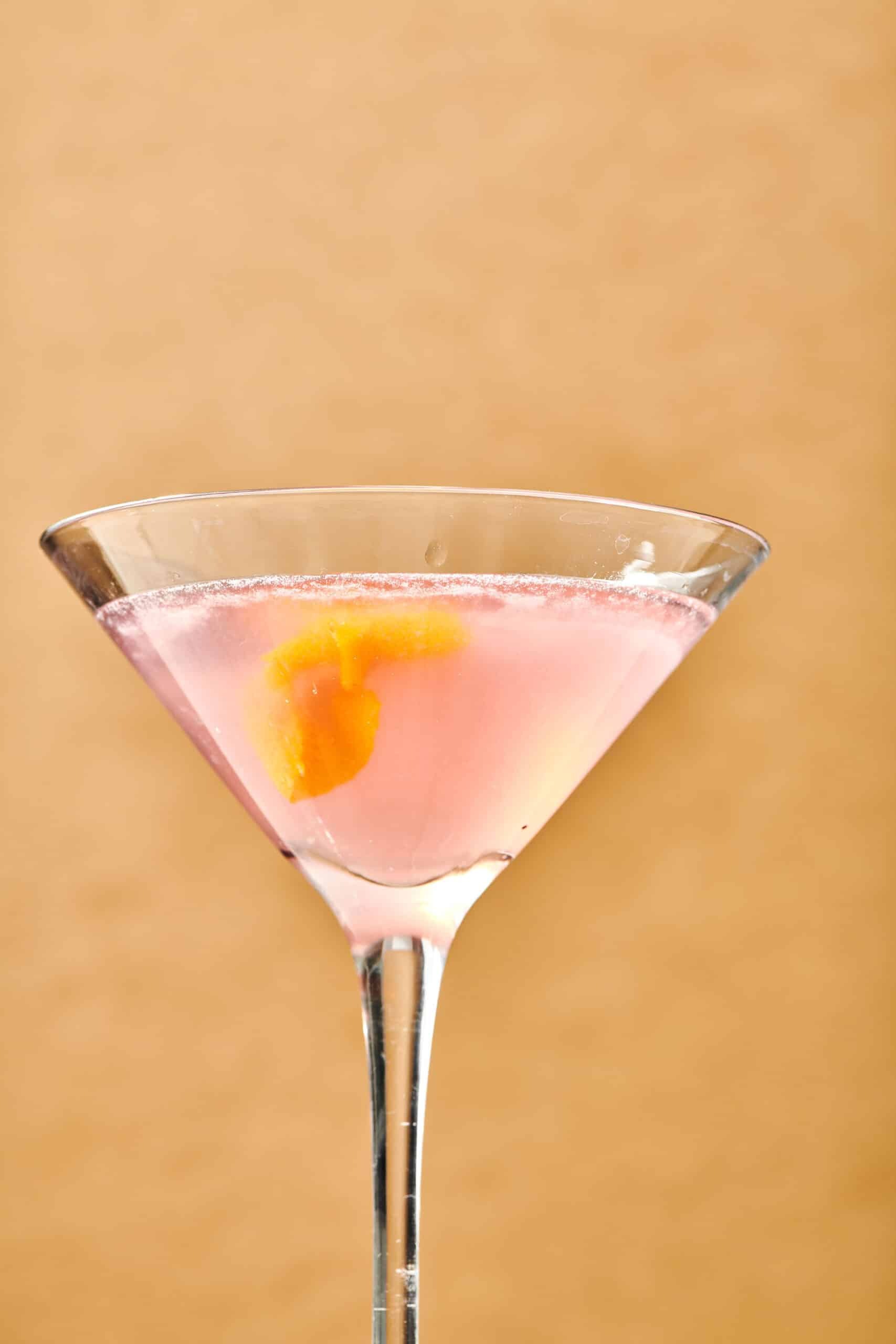 Pink Cosmo Cocktail in a long-stemmed glass.