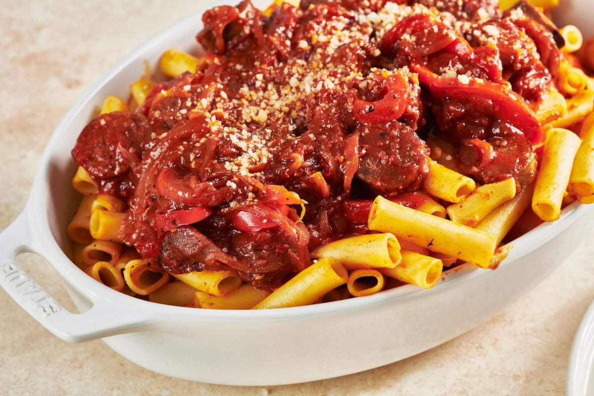 Sausage and Peppers Pasta in white serving dish.