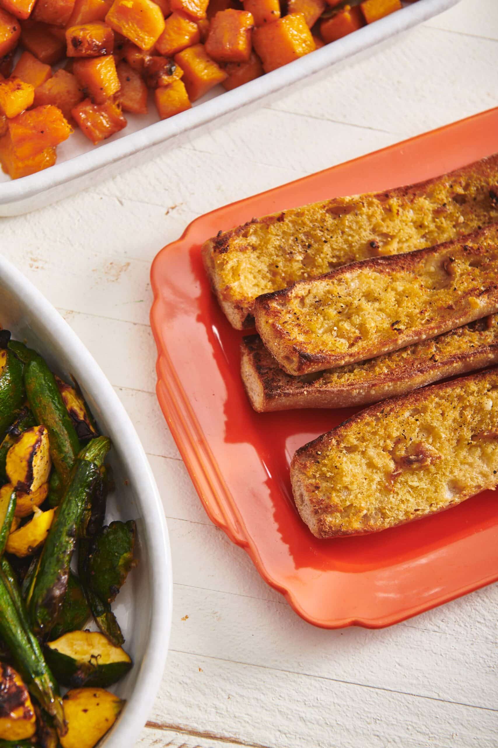 Vegan Garlic Bread piled on a red platter.