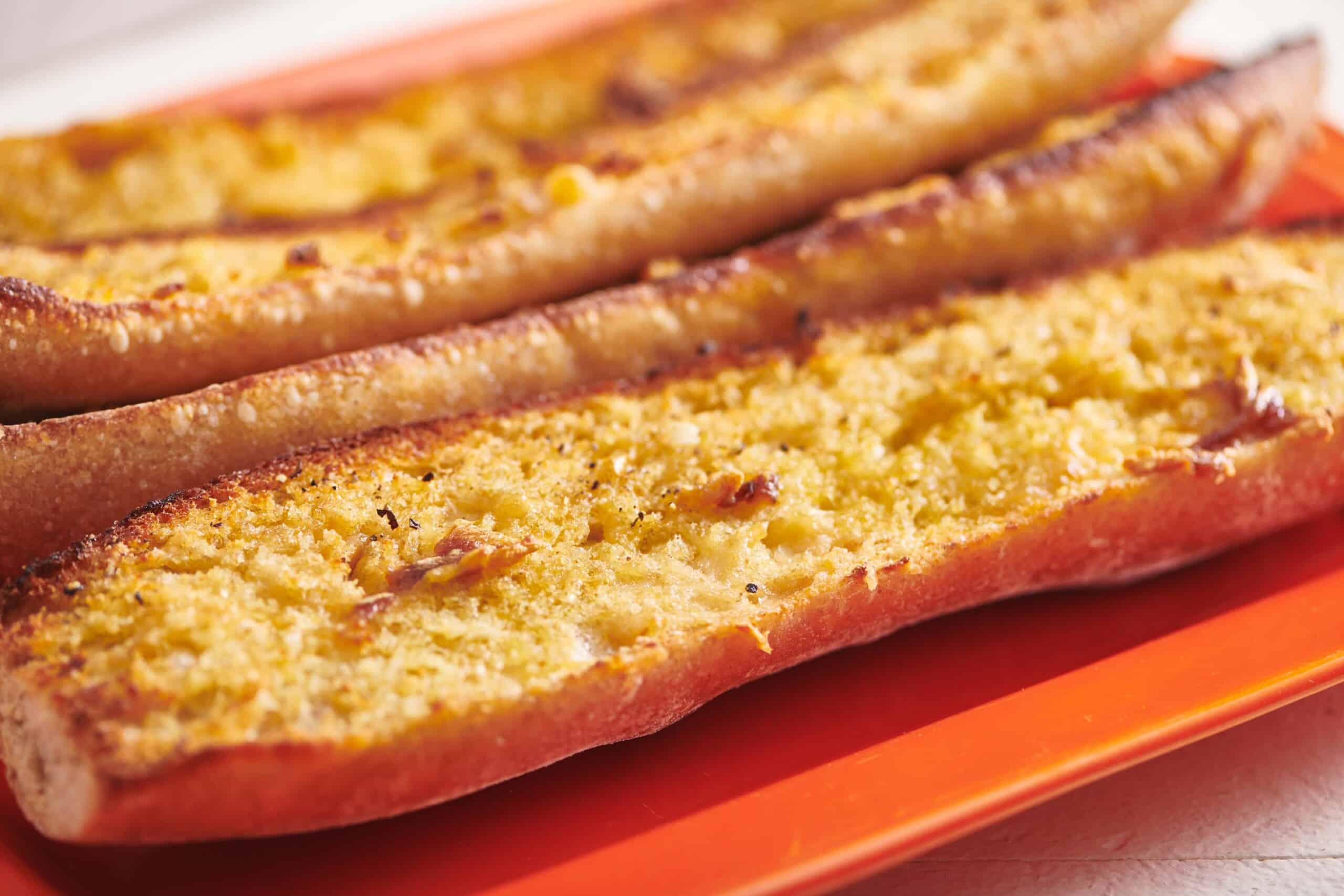 Vegan Garlic Bread on orange plate.