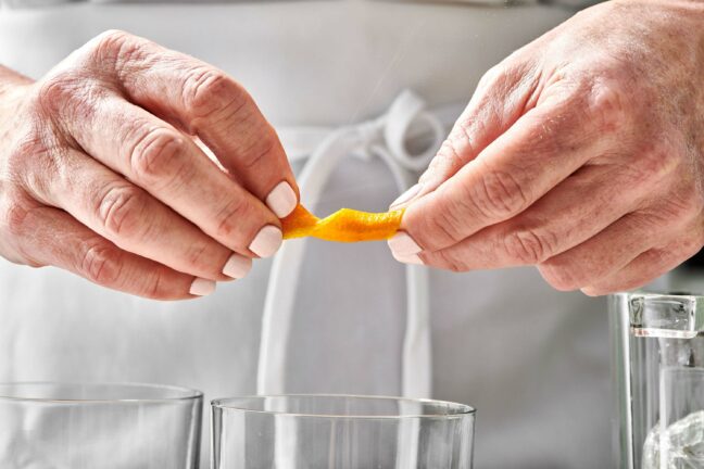 Woman twisting an orange peel.