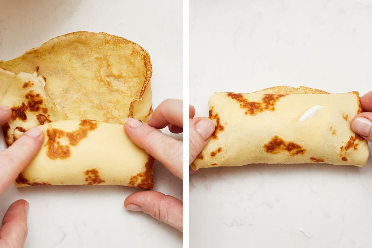 Woman rolling a crepe around the cheese filling.