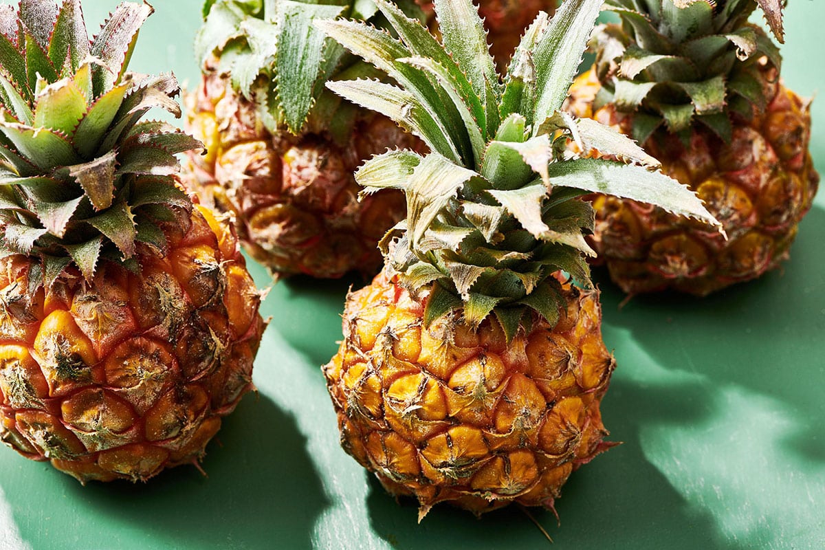 Baby pineapples on green table.