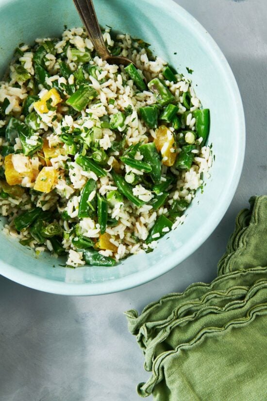 Spring Vegetable and Rice Salad with a fork in a bowl.