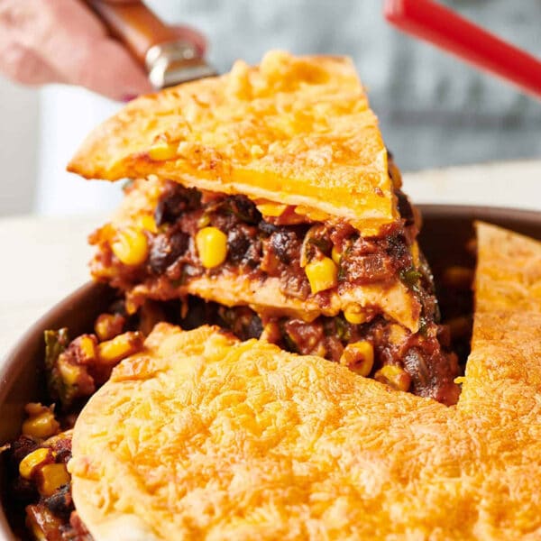 Removing slice of Vegetarian Mexican Lasagna from pan.
