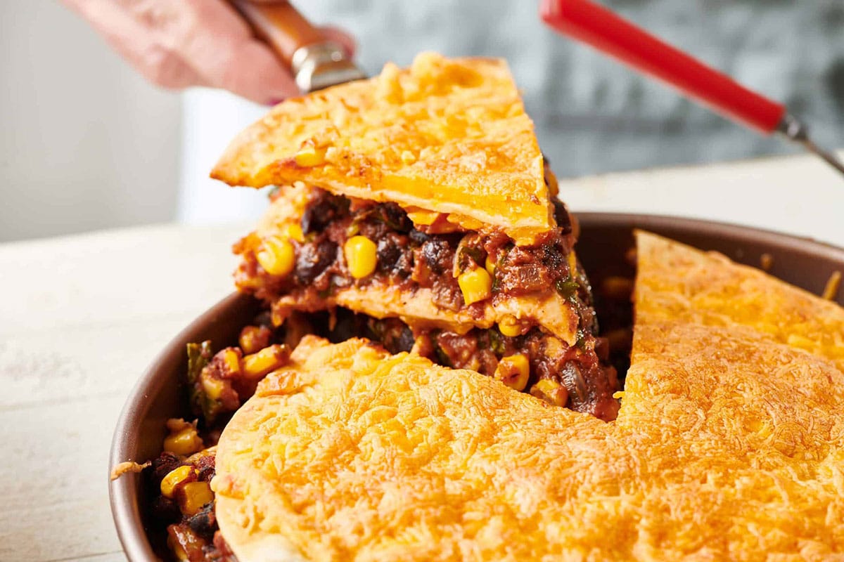 Removing slice of Vegetarian Mexican Lasagna from pan.
