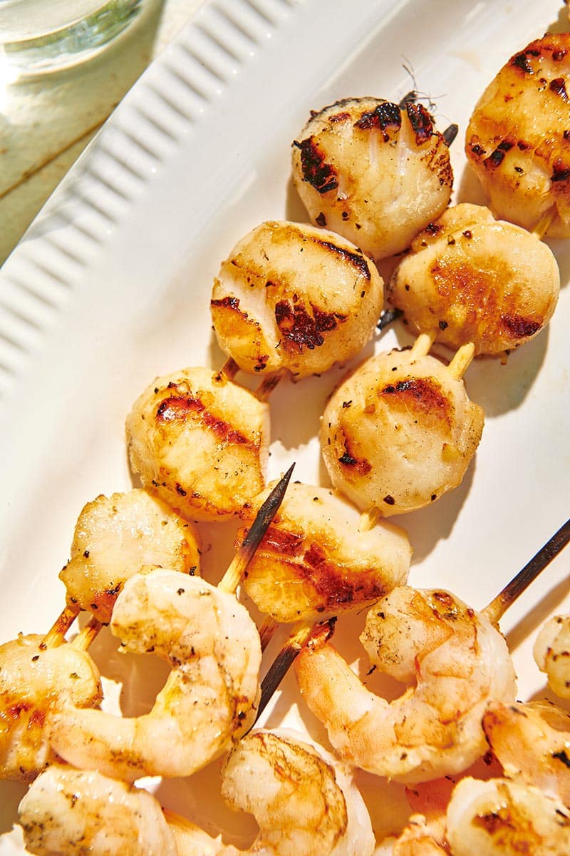 Skewers of Grilled Scallops on a white serving platter.