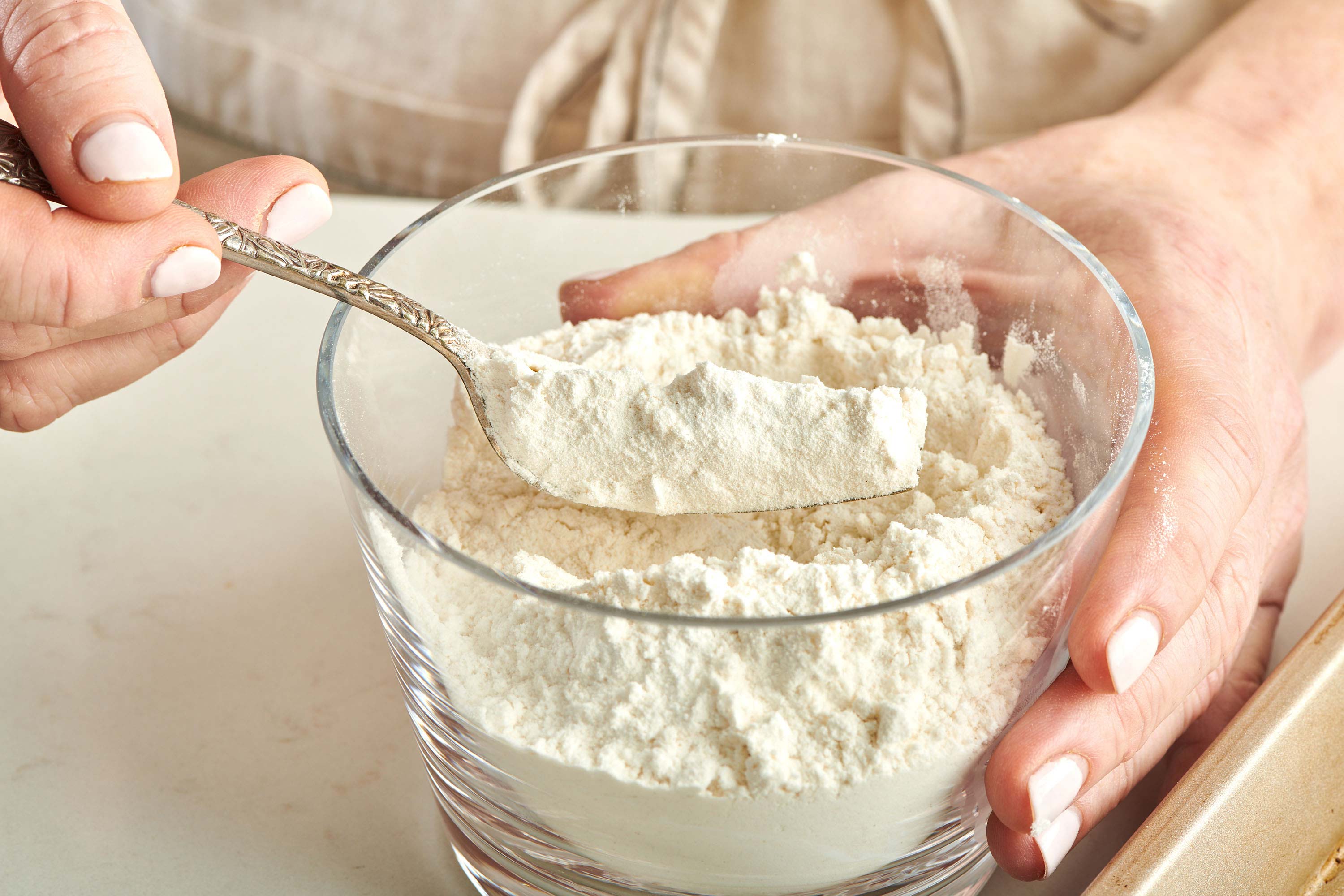 Woman holding a forkful of flour.