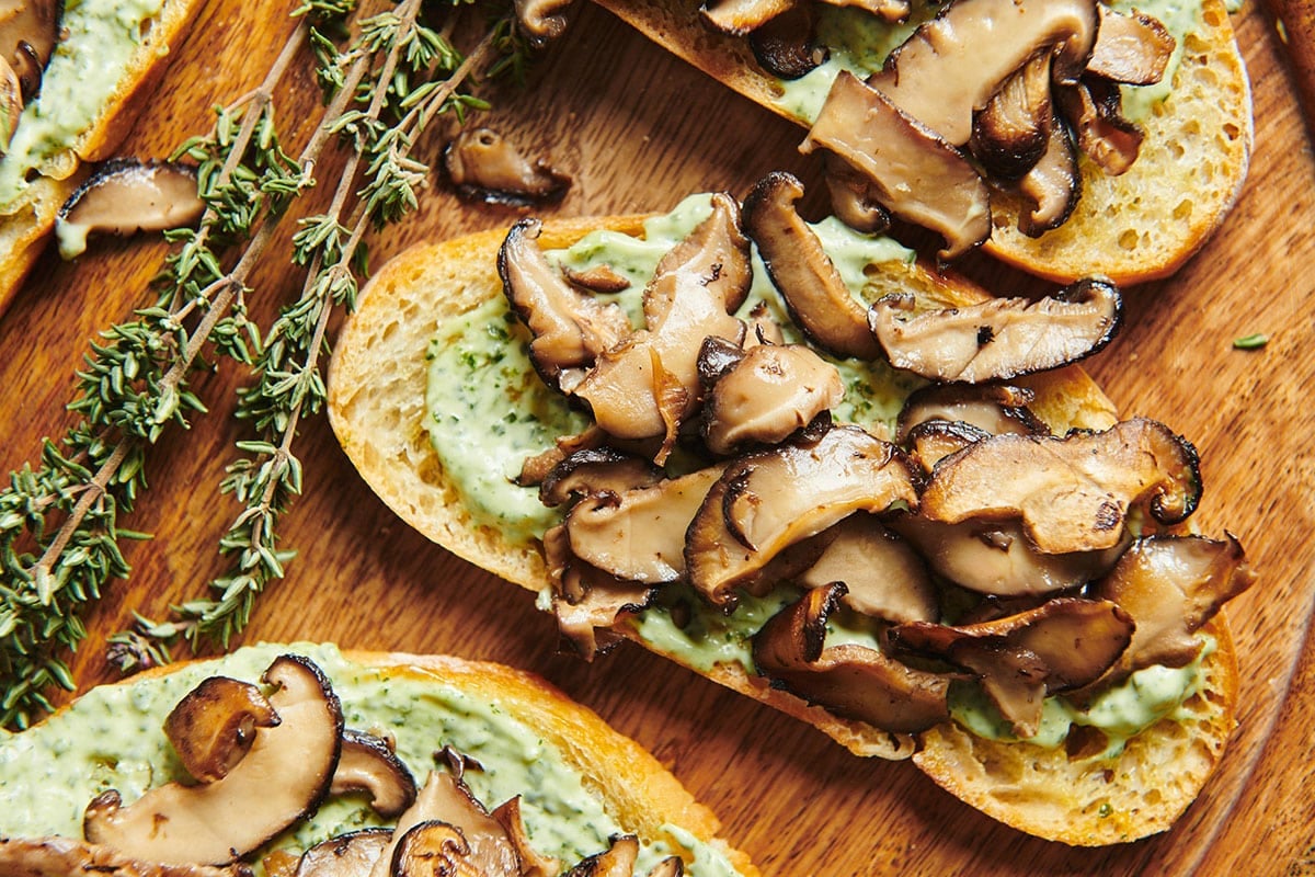 Mushroom Bruschetta with Herbed Mayonnaise on wood board.