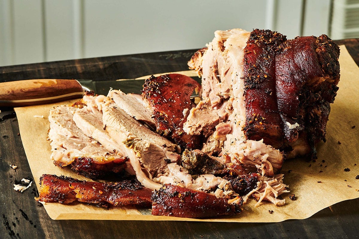 Partially-sliced Porchetta on parchment paper.