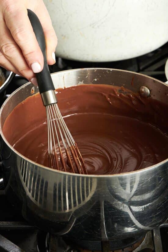 Woman whisking a pot of Chocolate Pudding.