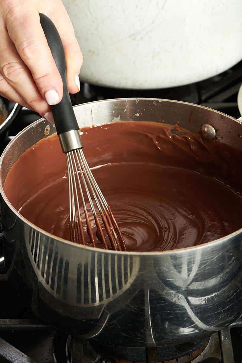 Woman whisking a pot of Chocolate Pudding.