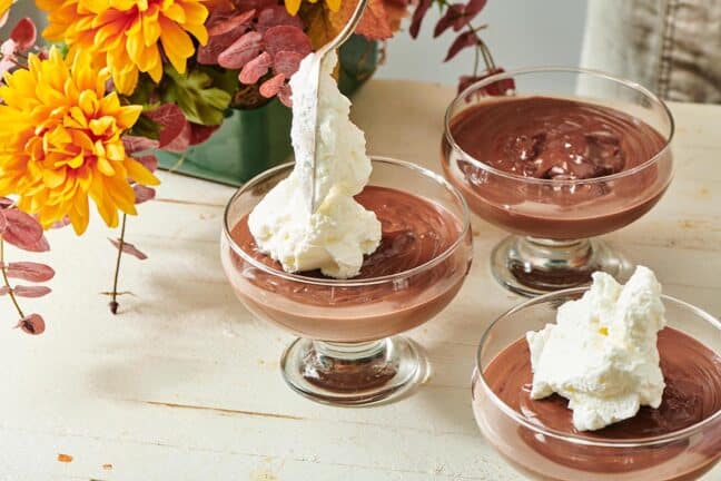 Spoon topping Chocolate Pudding with whipped cream.