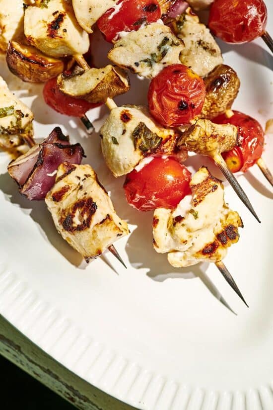 Grilled Chicken Kabobs with Vegetables set on a white platter.