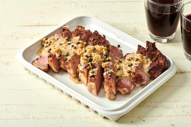 Steak slices topped with a creamy sauce with green peppercorns.