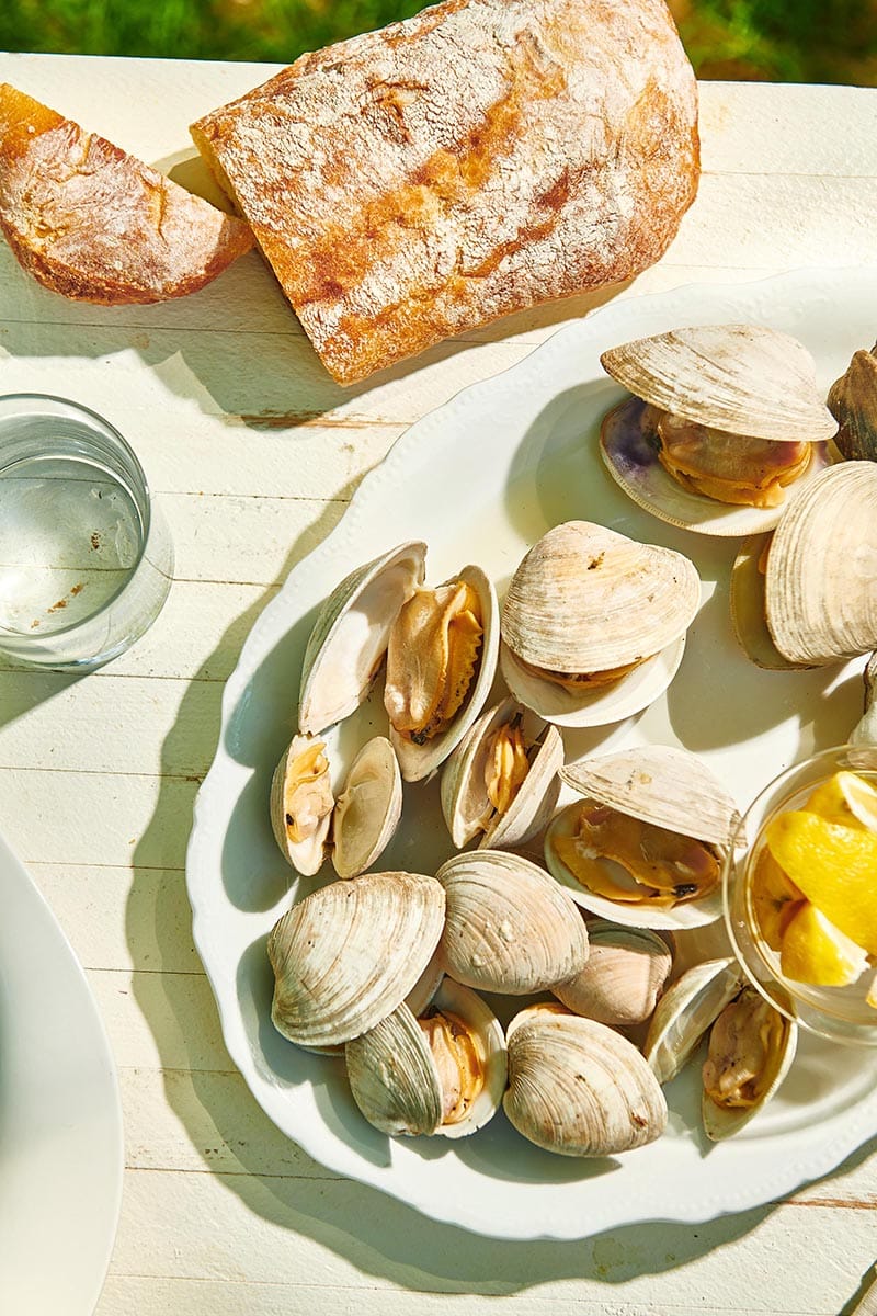 Grilled Clams on a table with bread.