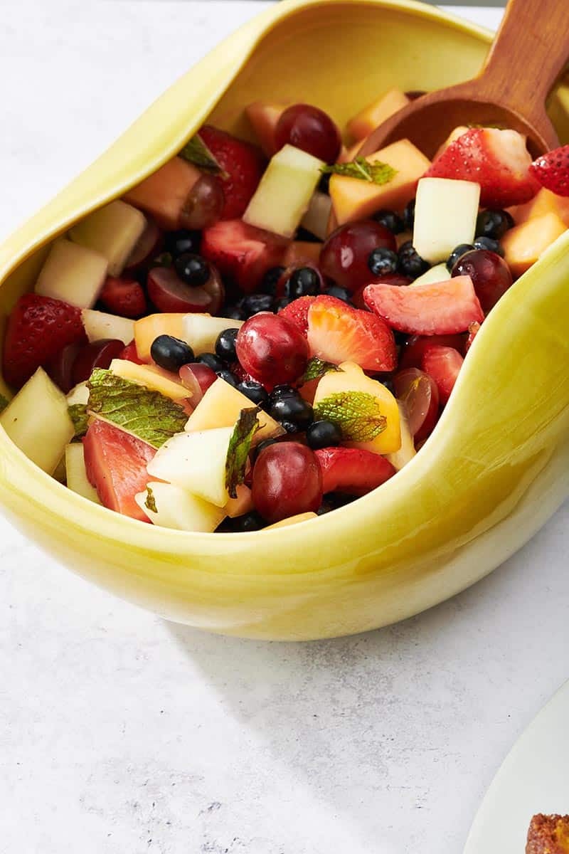 Colorful fruit salad in a yellow-green bowl.
