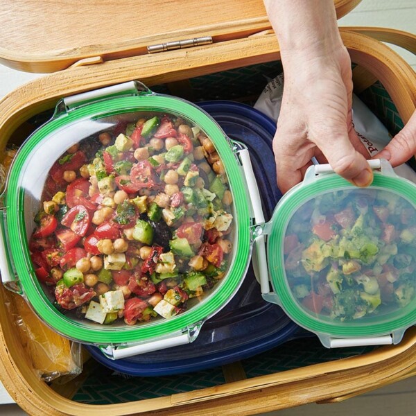 Plastic containers of colorful food in a basket.