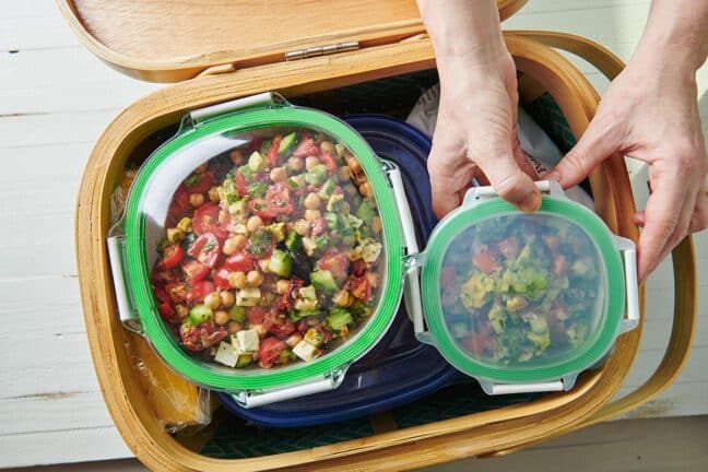 Plastic containers of colorful food in a basket.