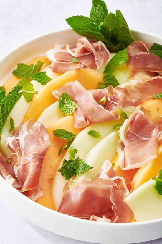 Prosciutto and Melon in a large white bowl.