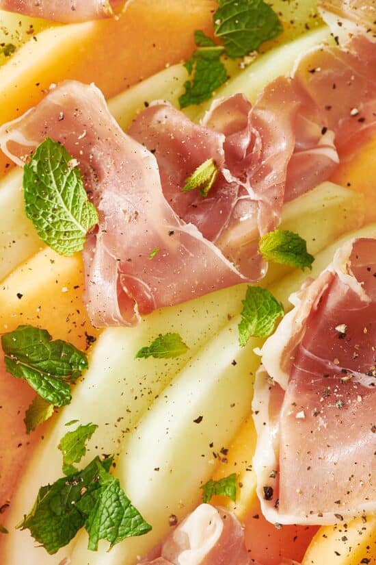 Orange and green melon topped with prosciutto and mint.