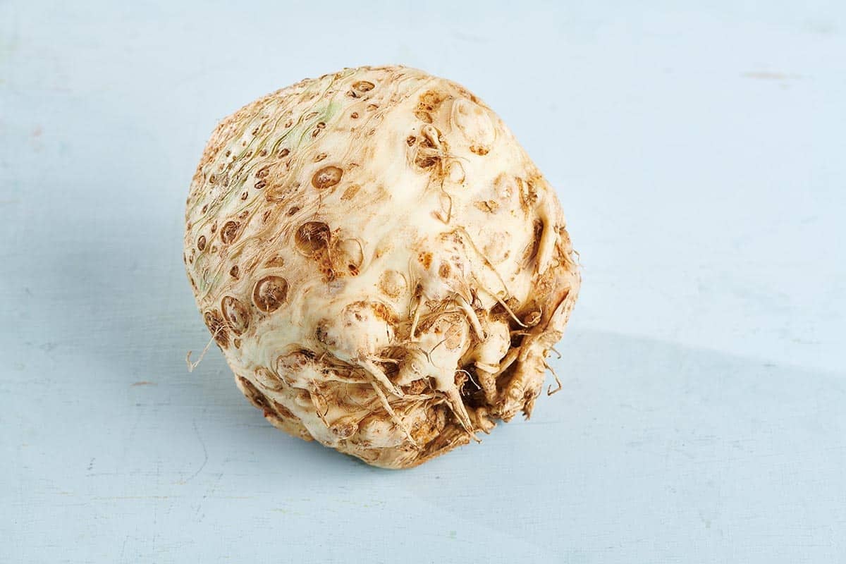 Whole celeriac with the skin still on sitting on a light table.