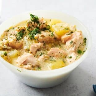 Bowl of Salmon Chowder on a light-colored table.